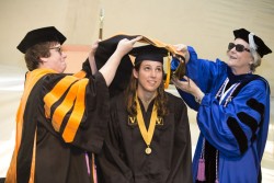 School of Nursing Founder’s Medalist Jessica Walker, MSN, APRN, center, receives her hood from Dawn Vanderhoef, Ph.D., DNP, left, and Mavis Schorn, Ph.D., APRN, CNM. (photo by Susan Urmy)