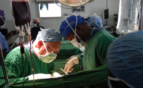 James O’Neill, M.D., left, instructs a surgical trainee in Kijabe, Kenya, on how to do a pericardial window for tuberculous pericarditis and tamponade. 
