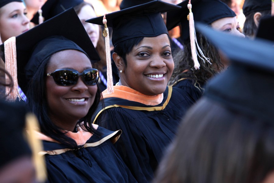 Ty Divine, left, and Angela Sterling, of the School of Nursing, smile during Commencement. (photo by Susan Urmy)