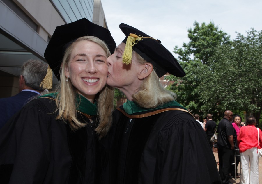 School of Medicine graduate Rachel Apple, left, gets a kiss from her mother,  Ann Price, M.D., VUSM’s associate dean for Alumni Affairs. (photo by Anne Rayner)
