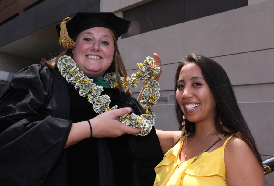 School of Medicine graduate Emily Cooperstein, left, shows off the money necklace made by fellow VUSM student Rachel Ruiz. (photo by Anne Rayner)