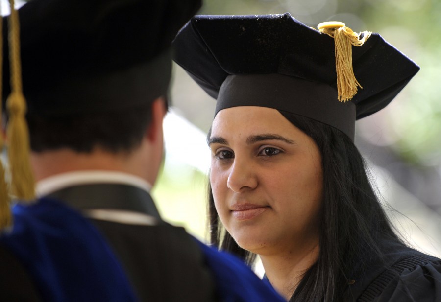 Maria Mercedes Abreu talks with a classmate at the Graduate School ceremony. (photo by Joe Howell)