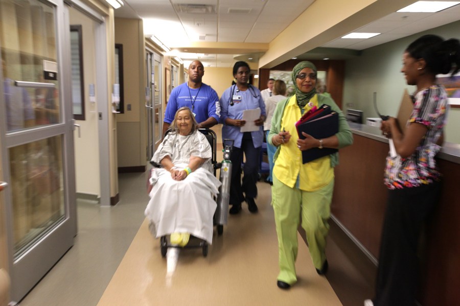 Patient Zana Kay Goats gets a ride to her new room in the Critical Care Tower with an assist from Todd Wade, Patient Transport, Tsega Andemicael, R.N., BSN, Tauhida Famau, R.N., and Princess Shelton, R.N., BSN. (photo by Anne Rayner)