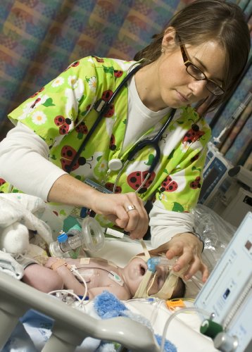 Natalie Gossum, R.N., attends to Silas Roberson, 24 days old, in the Pediatric Critical Care Unit. (photo by Susan Urmy)
