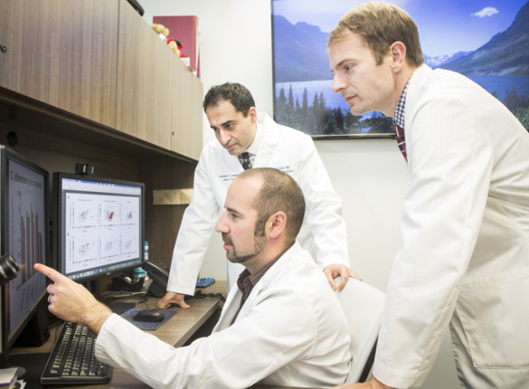 Justin Balko, Pharm.D., Ph.D., seated, Javid Moslehi, M.D., left, and Douglas Johnson, M.D., MSCI, review data on rare cardiac side effects linked to cancer immunotherapy combination therapy. (photo by Susan Urmy)
