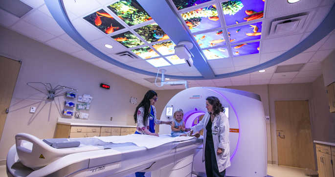 CT technologist Aussie Jookar, RT, left, and Marta Schulman, MD, introduce patient Gracen Langley, 3, to the new state-of-the-art CT machine at Monroe Carell Jr. Children’s Hospital at Vanderbilt.