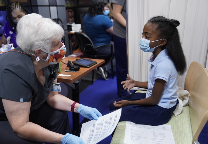 Amya Elliott, 9, talks with Bonnie Pilon, RN, prior to receiving her COVID-19 vaccination at Monroe Carell Jr. Children’s Hospital at Vanderbilt. The hospital began mass vaccination for children ages 5-11 on Monday, Nov. 8.