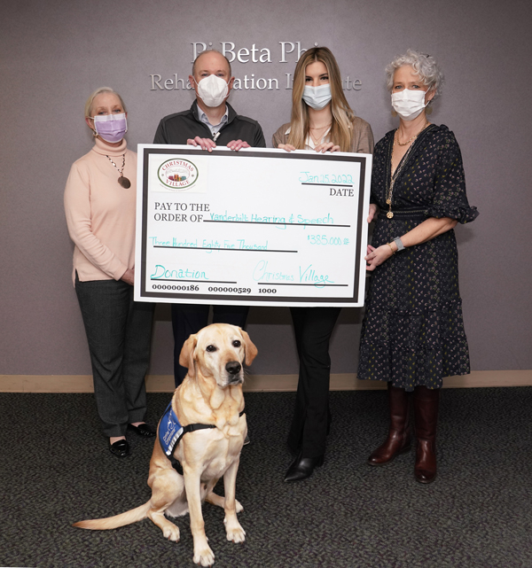 From left are Dominique Herrington, MS, Michael de Riesthal, PhD, Tiffani Kuhn, co-chair of Christmas Village, Susan Booth, co-chair of Christmas Village, and Norman, the Department of Hearing and Speech Sciences’ facility dog.