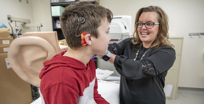 Rene Gifford, PhD, works with patient Davy Hillis to program his cochlear implant.