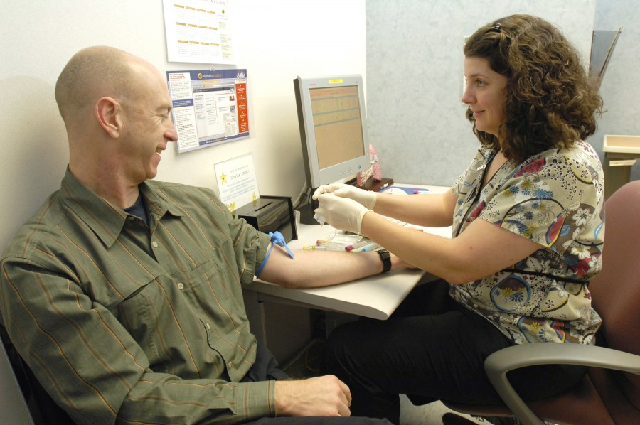 Study participant Ed Dailey has blood drawn by Wendi Mason, A.C.N.P., in the pulmonary clinic. (photo by Anne Rayner)