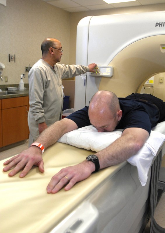 Ed Quirante, R.T., left, monitors Ed Dailey during his CT scan. (photo by Anne Rayner)