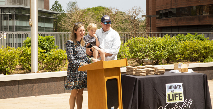 Pam Helmlinger, with her husband, Kelly, and 4-year-old son, Ryland, who received part of Kyle Fisher’s liver, speaks at VUMC’s Donate Life Month Flag-Raising Ceremony.
