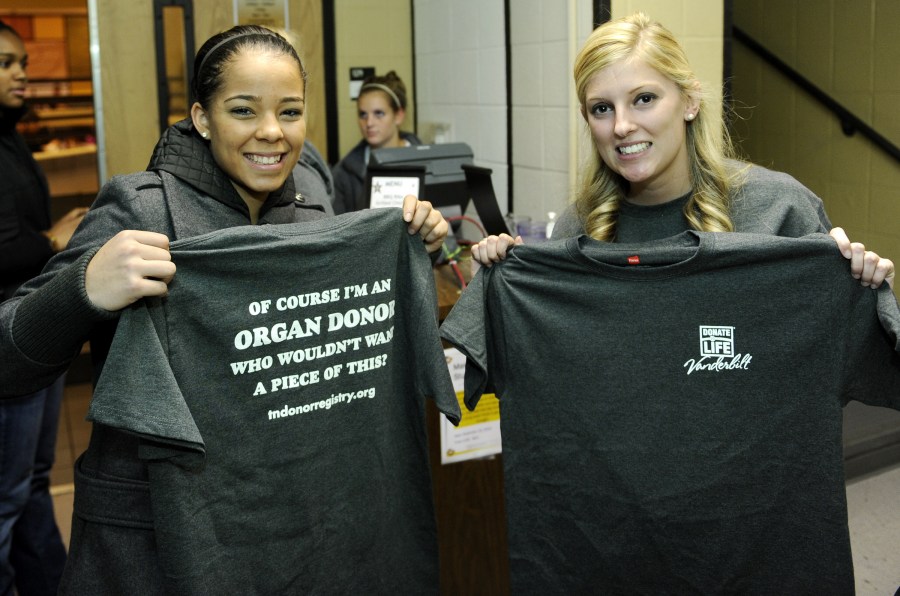Commodore basketball player Jasmine Lister, left, and Holly Isom, of Tennessee Donor Services, show off the T-shirts Vanderbilt students have been wearing this week in support of organ donation awareness. (photo by Joe Howell)