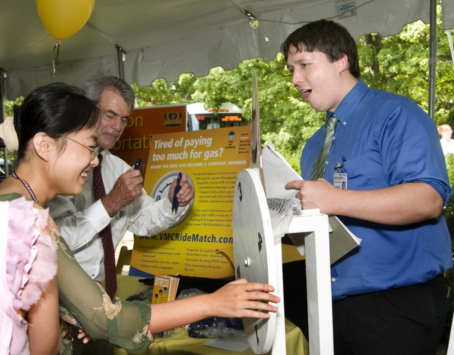 Joseph Barzizza, right, watches as Li Wang spins the wheel for a prize at Tuesday’s picnic. (photo by Susan Urmy)