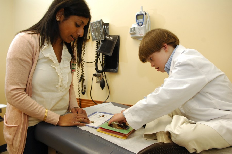 Niru Madduri, M.D., and 11-year-old Michael Blackburn demonstrate the communication tools used to reduce anxiety about clinic visits. (photo by Anne Rayner)