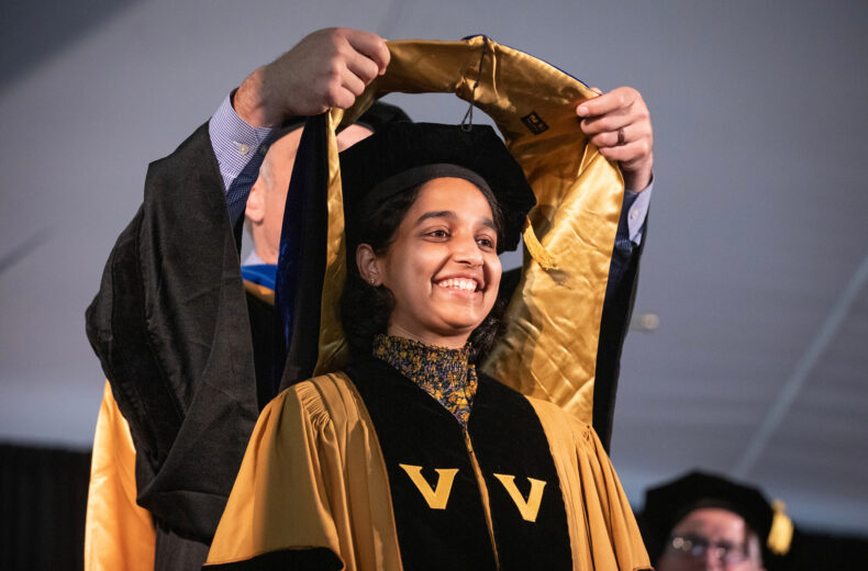 Arya Nakhe, PhD (Molecular Physiology and Biophysics), is hooded by David Jacobson, PhD during the Graduate School commencement ceremony. (photo by Erin O. Smith)