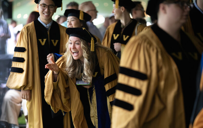 Emily Thompson, PhD (Hearing and Speech Sciences), waves to family during the Graduate School commencement ceremony. (photo by Erin O. Smith)