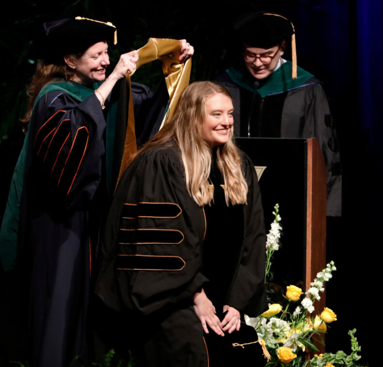 Kasey Hutcheson, MD, receives her hood from Amy Fleming, MD, MScHPE. (photo by Donn Jones)