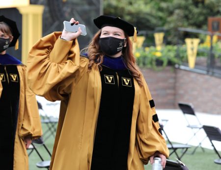 Emily Kimball, who received her PhD in Hearing and Speech Sciences, waves to supporters during the Graduate School ceremony. 