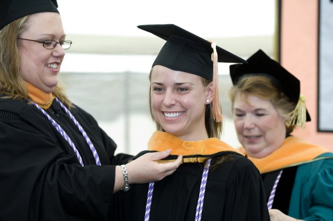 Danielle Brewer receives her School of Nursing academic hood from Leslie Welch Hopkins, M.S.N., left, and Linda Norman, D.S.N., R.N. (photo by Susan Urmy)