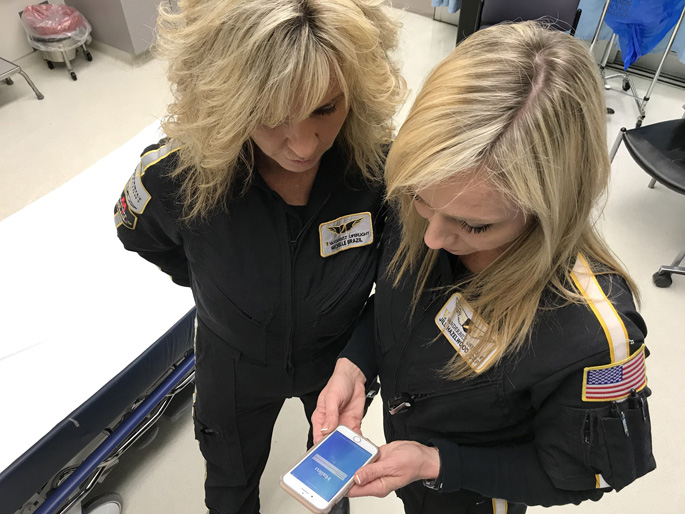 LifeFlight’s Michelle Brazil, RN, EMT, left, and Jill Hazelwood, CCP, work with the Haiku app to view patients’ medical records.