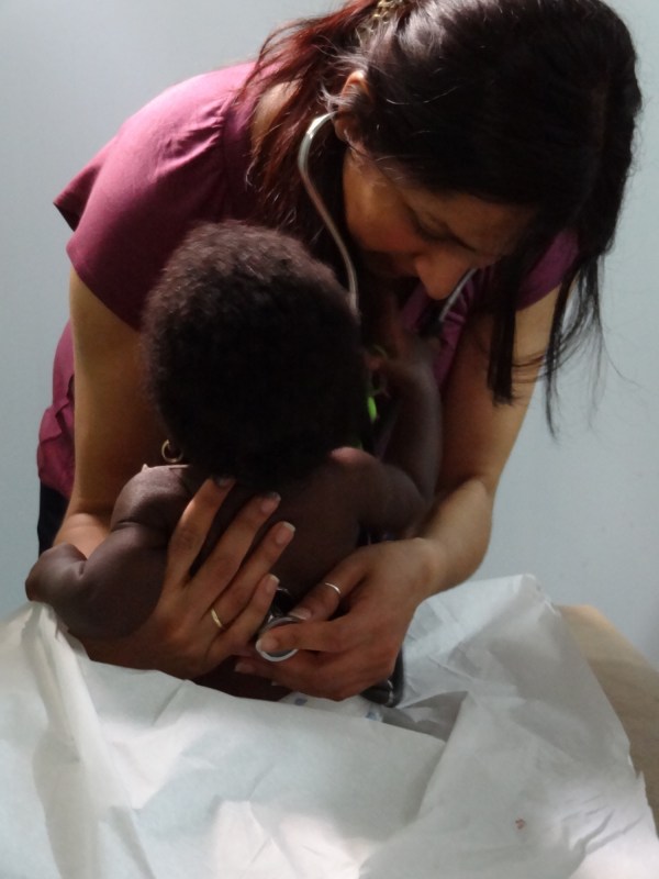 Neeru Kaushik, M.D., examines a child during the team’s visit to Haiti. (photo by James Abbas)