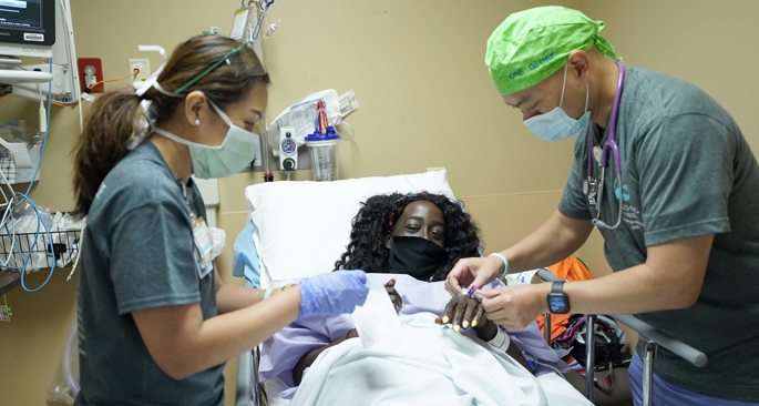 Patient Clearissa Griggs gets a pre-surgical check from Caroline Wilburn, RN, BSN, and attending anesthesiologist Chris Canlas, MD, during Vanderbilt University Medical Center’s “Touching Hands” Outreach Day.