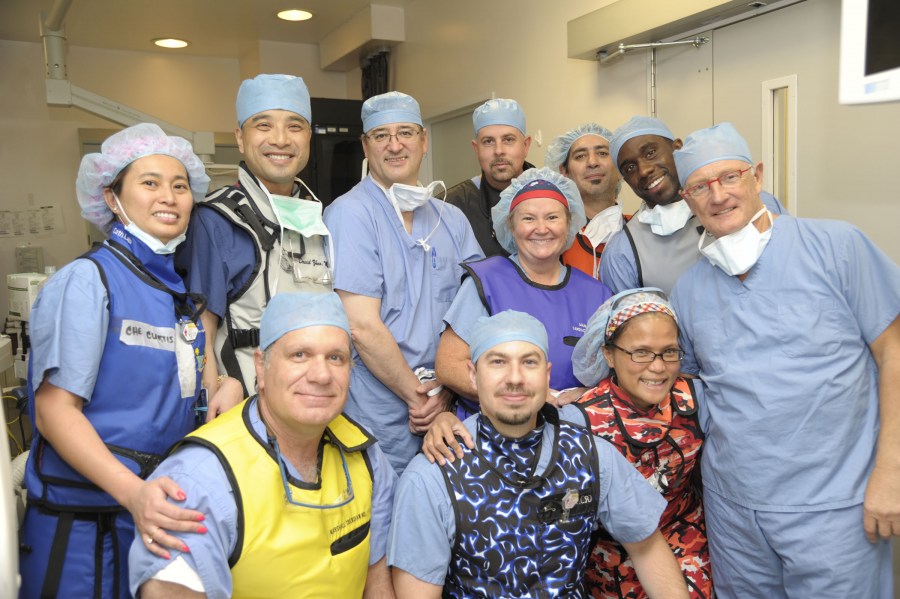 The surgical team for the new minimally invasive catheter procedures included (front row, from left) Marshall Crenshaw, M.D., Waylon Cotter, Ida Oudomsouk, R.N.2, Eberhard Grube, M.D., (middle row, from left) Chi Curtis, R.N.2-CC, David Zhao, M.D., Joseph Fredi, M.D., Lynn Blair-Anton, RNS-IV, Jerry Talbert, (back row, from left) Kevin Daigle and Bill McGee.  (photo by Lauren Owen)