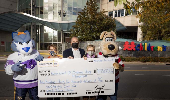 On hand for the outdoor check presentation were, from left, Nashville Predators mascot GNASH, Meg Rush, MD, MMHC, Children’s Hospital President, Samuel Perry, Twice Daily Regional Director of Operations, Michelle Kennedy, Nashville Predators Chief Operating Officer, and Hospital mascot Champ. (photo by Susan Urmy)