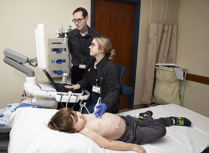 Bryan Burnett, MD, and cardiac sonographer Courtney Ehrich examine Oliver Hutson during a recent weekly checkup. (photo by Susan Urmy)