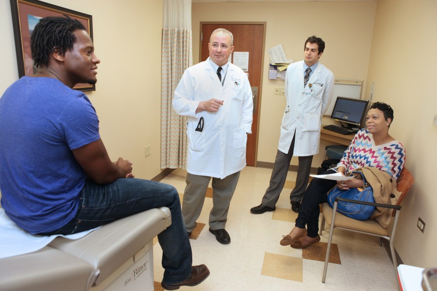 Terry Lee, left, and Latrisha Beckwith talk with surgical team members Douglas Hale, M.D., and Michael Vella, M.D., during a pre-transplant consultation. (photo by Susan Urmy)