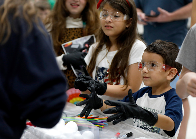 Thiago Borrero, 5, is gloved and ready for action at the first station of the MEGAMicrobe community science event held Sept. 23 at Gower Elementary School in Nashville, as his sister, Samantha Borrero, 9, observes the rules of the game. 