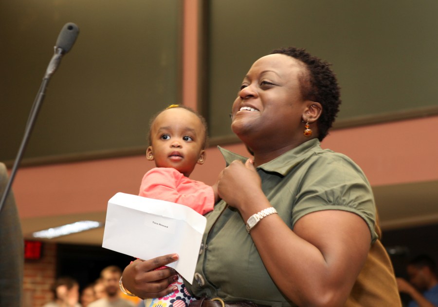 Tera Howard holds Eva, eight months old, after learning she’s going to Chicago. (photo by Susan Urmy)