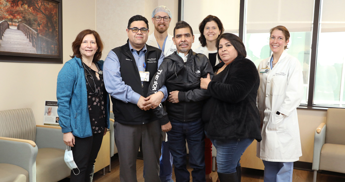 José Ontiveros, center, and his wife, Isela Morales, to his left, are surrounded by some of the team members who helped save his life as he battled post-COVID complications, including from left, infectious disease specialist Karen Bloch, MD, MPH; interpreter Eleazar Jimenez; orthopaedic surgeon Amir Abtahi, MD; infectious disease specialist Christina Fiske, MD, MPH; and otolaryngologist Sarah Rohde, MD, MMHC.