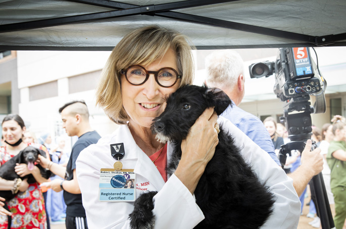 Robin Stefan, RN, MSN and Chief Nursing Officer,  hold puppy while Nashville Humane Association (NHA) introduces Paws on the Plaza, an event in which the NHA will bring adoptable puppies to the VUMC Plaza. Although this is not an official adoption event, all puppies are available for adoption through NHA following the event.  While NHA offers Bark Breaks throughout the Nashville/Middle Tennessee area, we are thrilled to be the first hospital to enter this partnership.  Photos by: Susan Urmy