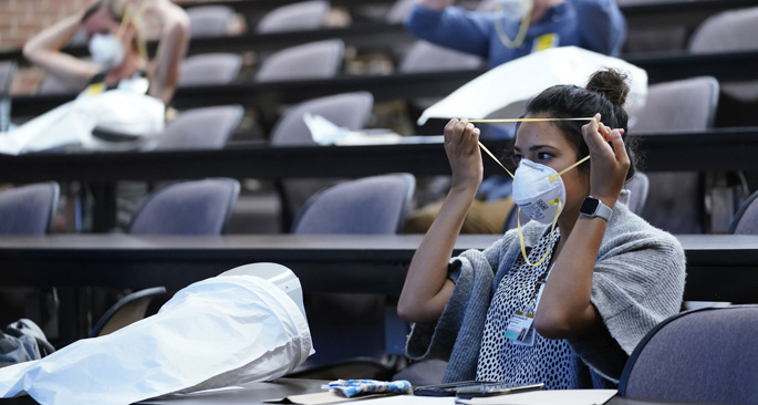 Sarah Hmaidan, DO, tries on a N95 respirator in Light Hall during orientation for incoming residents and fellows.