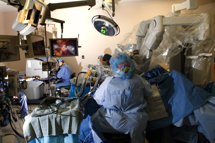 Using the da Vinci Surgical System, Joseph Smith, M.D., far left, controls the robot that performs the surgery. (photo by Susan Urmy)