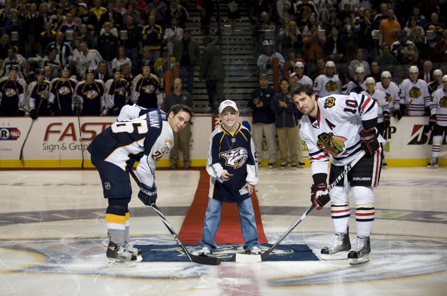 Here, patient Trace Kimler drops the puck at the team’s Oct. 29 game, which benefited the Childhood Cancer Program. (photo by Joe Howell)
