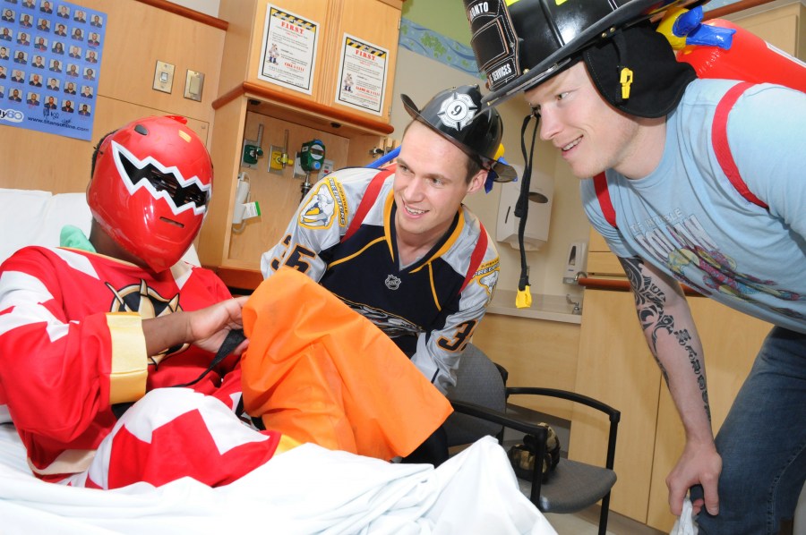 Here, patient Larry Tate gets some goodies from Predators players Pekka Rinne, center, and Wade Belak during last week’s reverse trick or treat event. (photo by Mary Donaldson)
