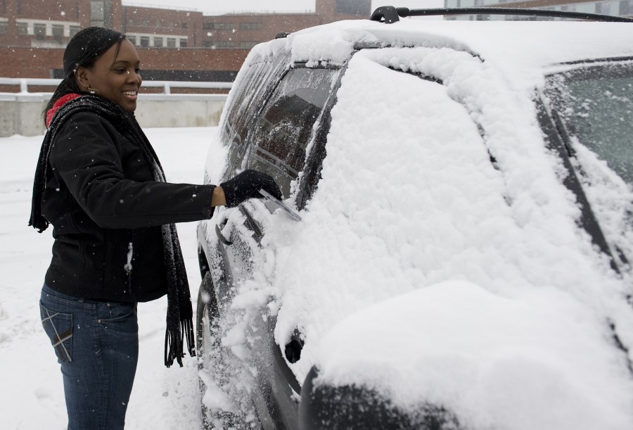 Gift Shop sales associate Reena Black scrapes her car windows as she prepares to go home. (photo by Joe Howell)