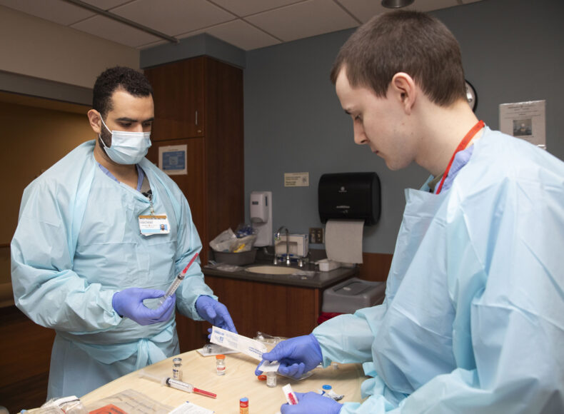 Rotators Wilson Fernandez, RN, CCRN, left, and Richard Wallace, LPN, in the Surgical Intensive care unit.