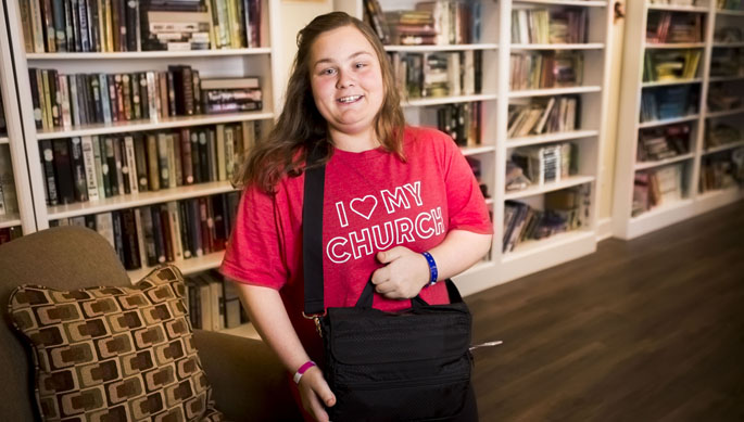 Trinity Scott holds a bag containing the portable ventricular assist device that served as a bridge to her eventual heart transplant.