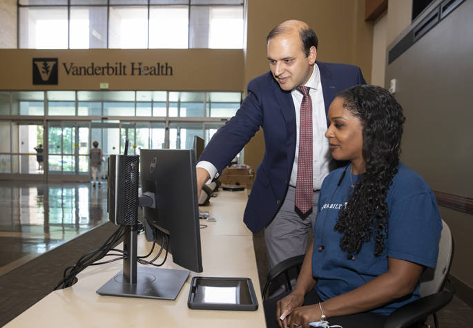 Tiffany Mays, a senior patient services representative, and Chetan Aher, MD, Associate Chief Medical Officer of Adult Ambulatory Clinics, take a first look at the new centralized welcome desk at Vanderbilt Health One Hundred Oaks. (photo by Erin O. Smith)