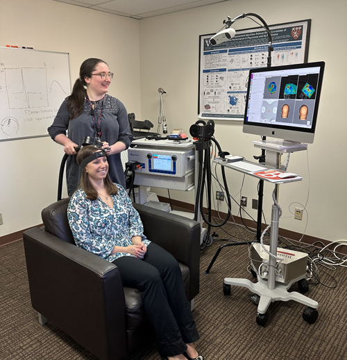 Research assistant Sophia Blyth demonstrates rTMS targeting on Heather Burrell Ward, MD, who is leading a study of the procedure as a potential smoking cessation treatment in people with schizophrenia.