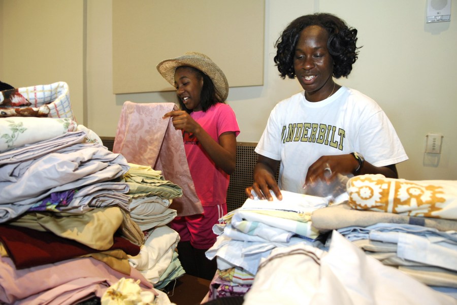 Dandre Hill, right, and her daughter, Kaiandra Franklin, fold sheets at the swap. (photo by Anne Rayner)