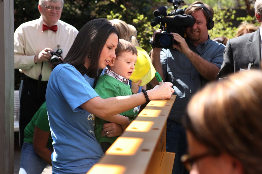 Kenette Jones and her son, Trent, 2, add their names at last week’s beam-signing event celebrating the start of construction of the Monroe Carell Jr. Children’s Hospital at Vanderbilt expansion project. (photo by Susan Urmy)