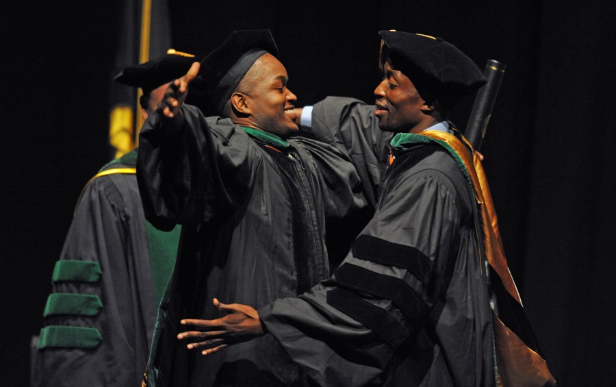 Fred Ochieng,' right, hugs his brother, Milton Ochieng,' M.D., after receiving his VUSM diploma. (photo by Joe Howell)