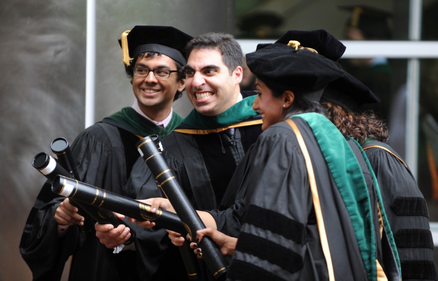 Kunal Sharma, left,  Andre Boustani and classmates ham it up after receiving their School of Medicine diplomas. (photo by Joe Howell)