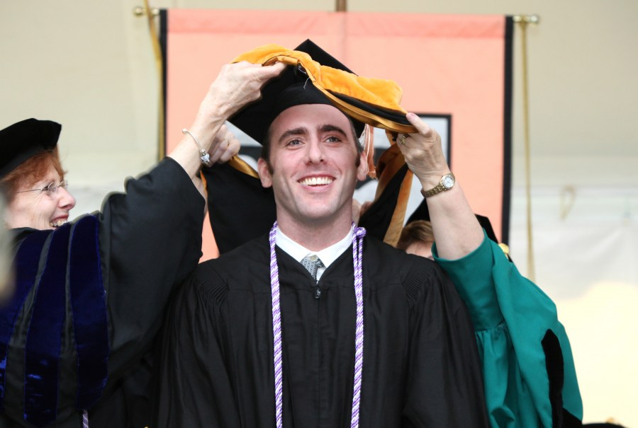 Robert Hall cracks a smile as he receives his School of Nursing academic hood. (photo by Susan Urmy)