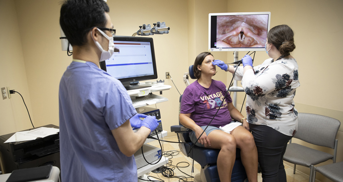 Yike Li, PhD, and Maria Powell, PhD, examine patient Judit Kiss during a follow-up appointment at the Vanderbilt Voice Center.